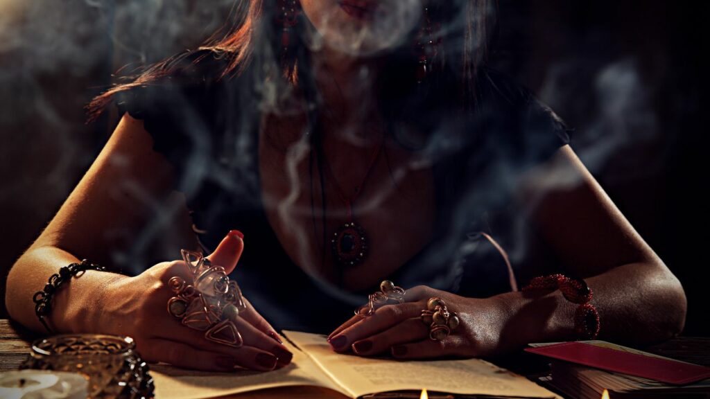 Femme pratiquant la divination avec des cristaux et de la fumée sur un livre ancien.
