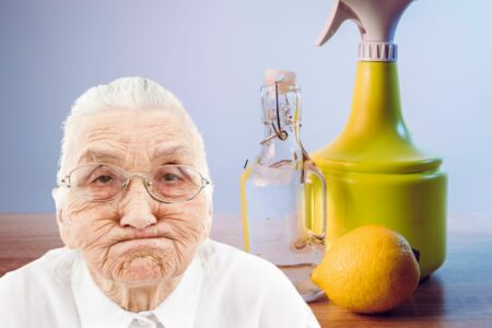 Une femme âgée avec du bicarbonate, du vinaigre et un citron sur une table.